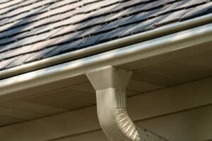 beige gutters on a home with a brown asphalt roof