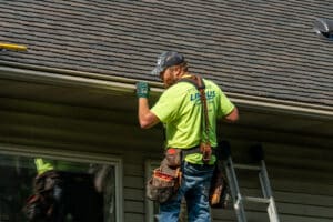 gutter installer placing new gutters on a home