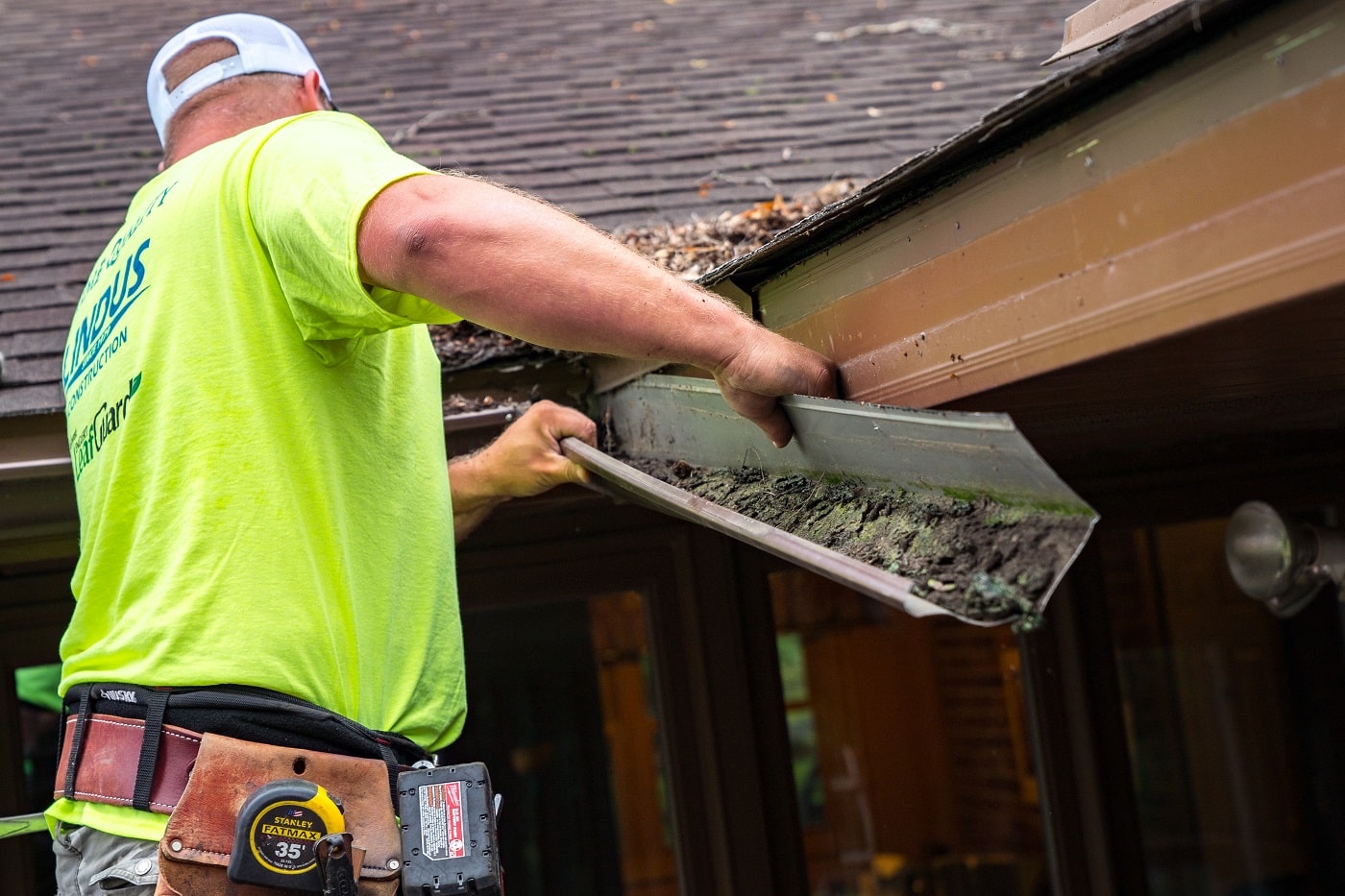 gutter installer removing clogged gutter