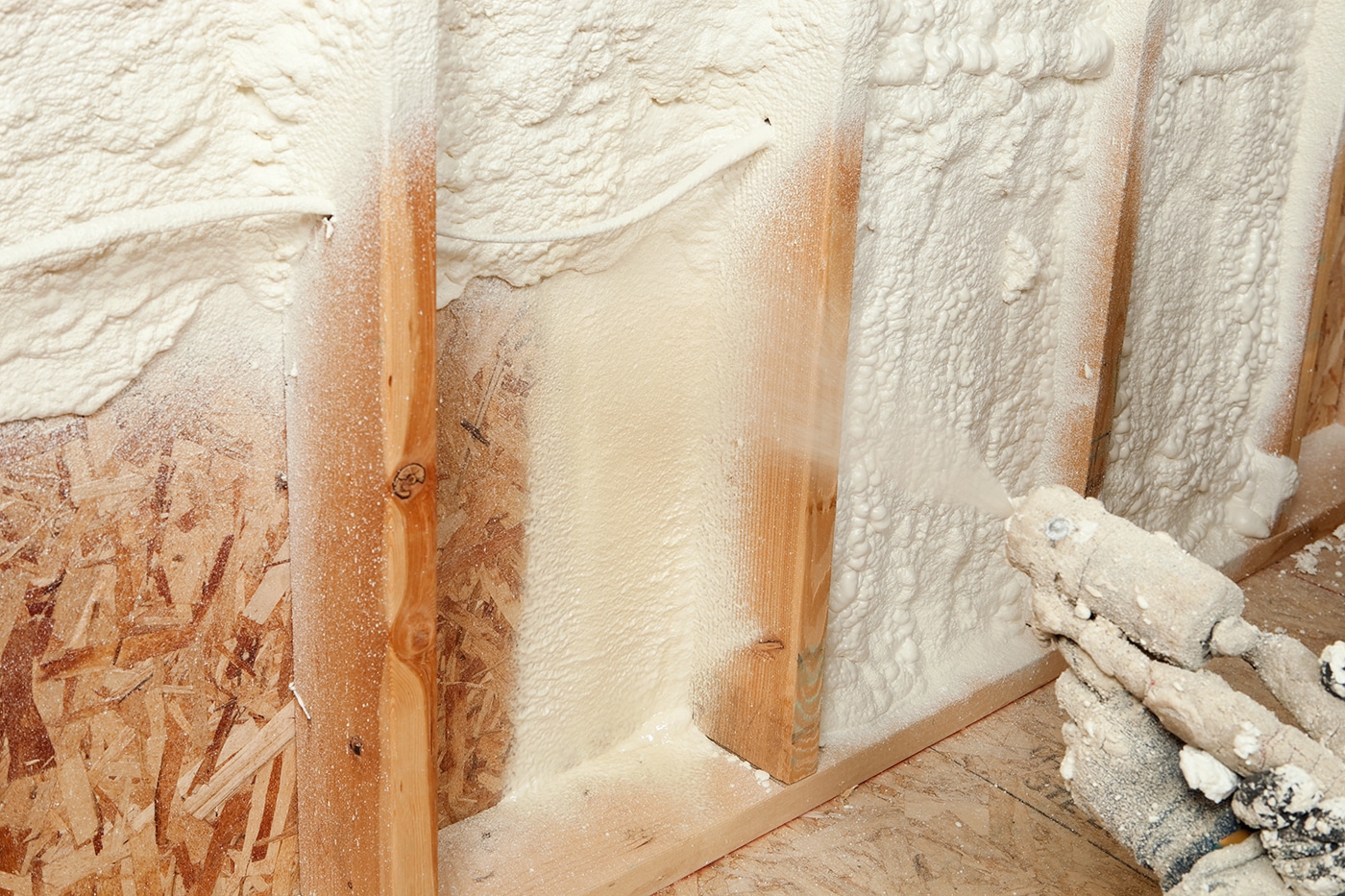 Spray foam insulation being applied to a wall cavity in a home