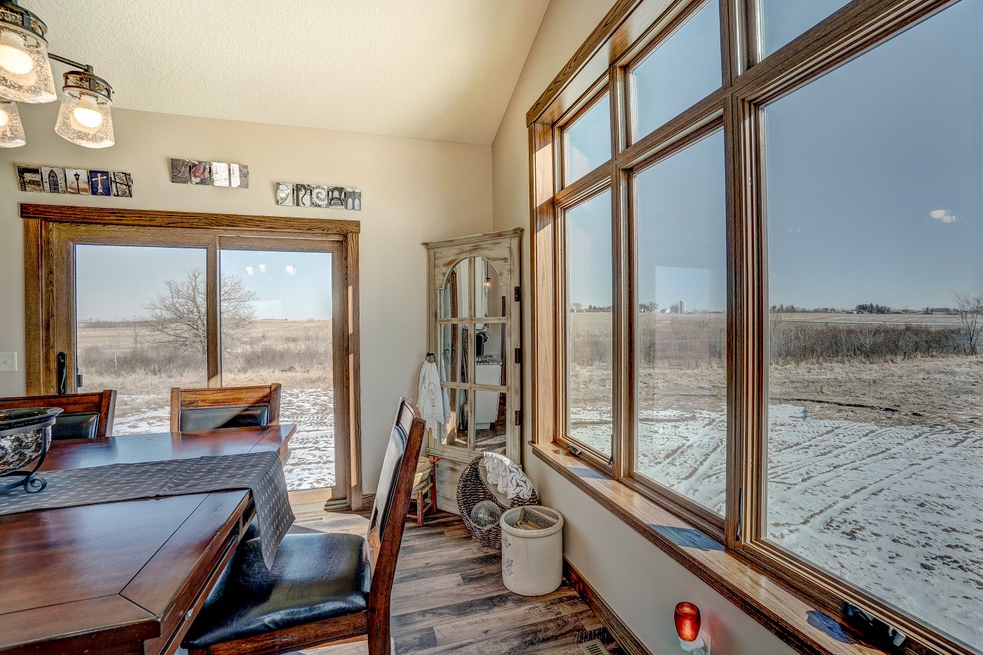 Home with large picture windows showing a snow covered field