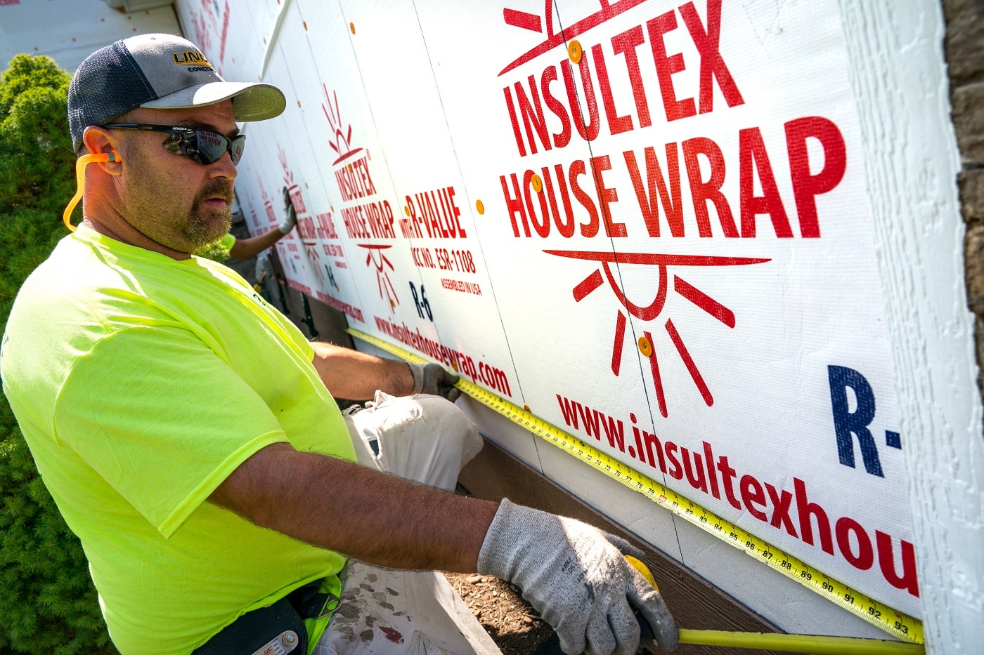 Lindus Construction Worker Installing House Wrap 