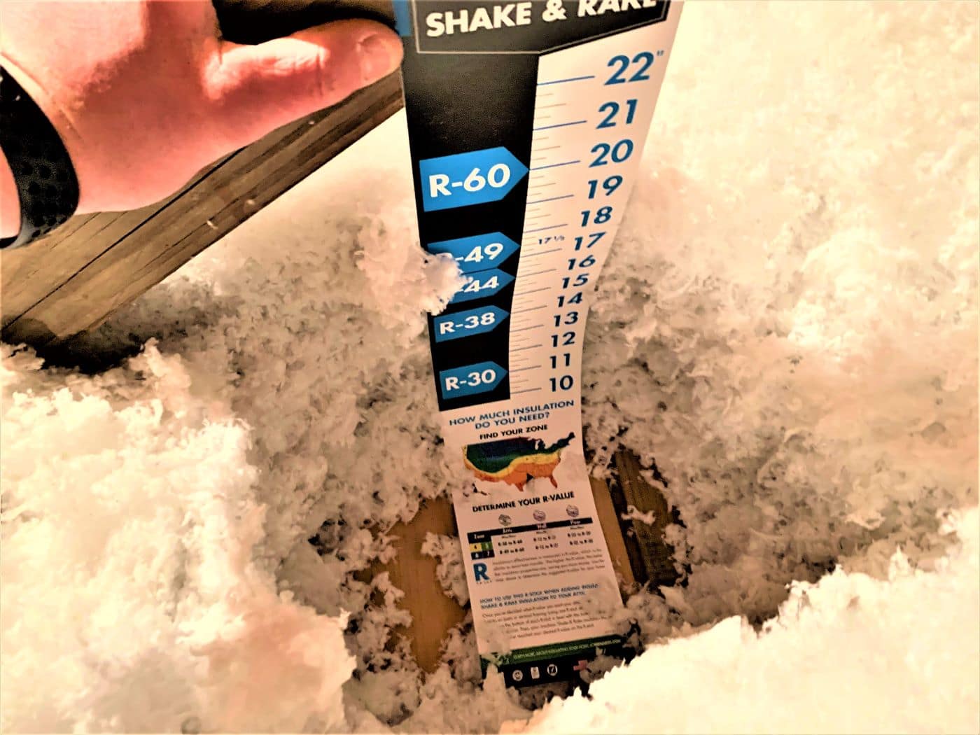 Bent insulation measuring stick showing the wrong level of insulation