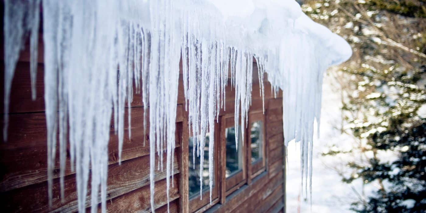 Ice dam along a roof edge during winter that can contribute to attic moisture damage